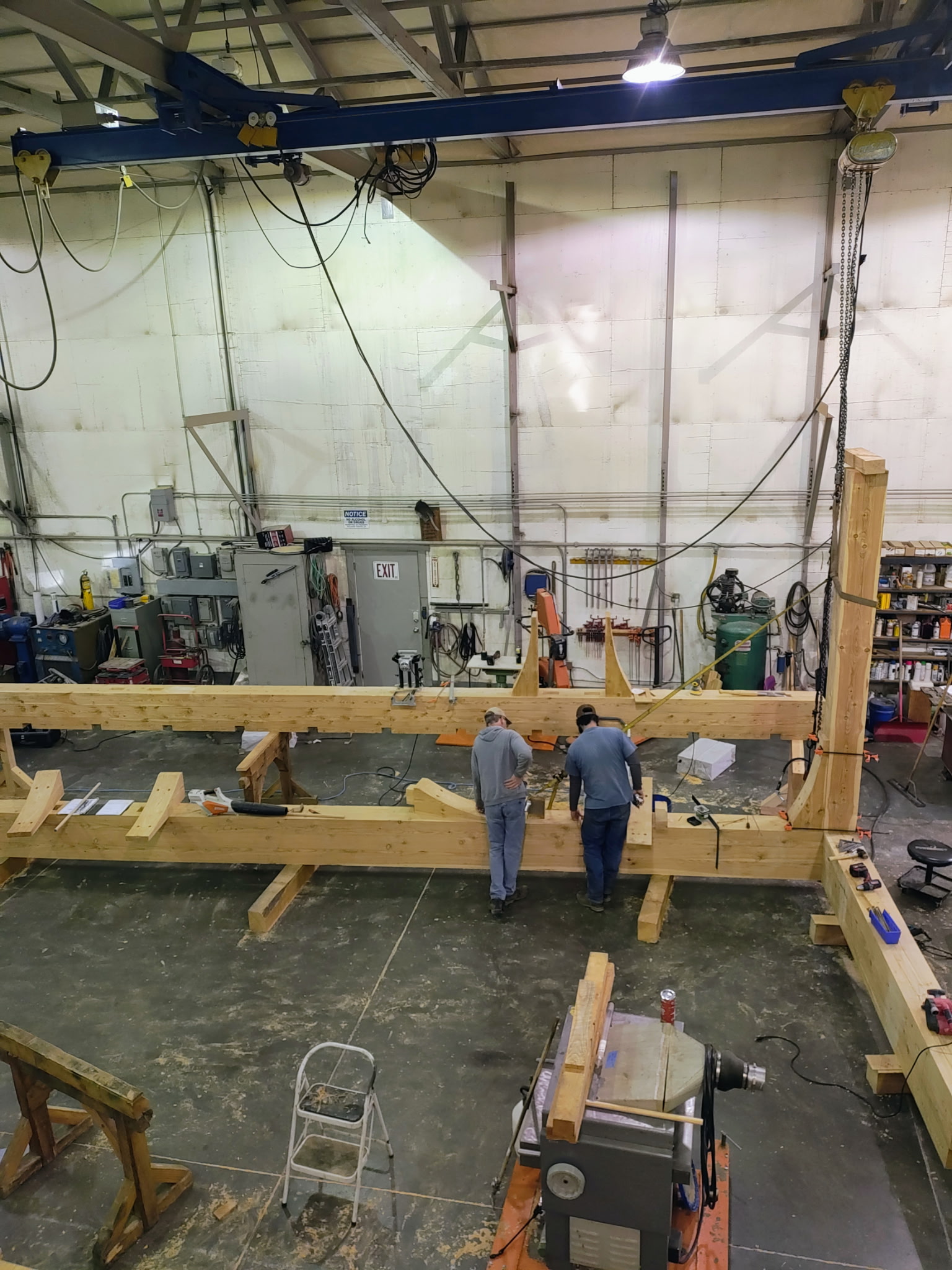 Craftsmen assembling a large structural timber frame in the Montana Beams workshop